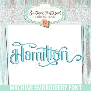 May include: A teal-colored embroidery font spelling the name "Hamilton" in a cursive style. The image includes the text "Boutique Fonts.com" and "MACHINE EMBROIDERY FONT". The background is white with a light blue wood pattern.