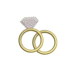 Peut inclure: Motif brodé de deux alliances dorées entrelacées, surmontées d'un diamant argenté en forme de losange. Les anneaux sont de couleur or chaud, et le diamant a un aspect texturé. Le motif est sur fond blanc.