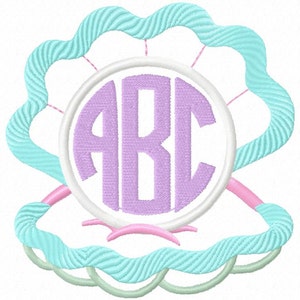 Puede incluir: Diseño bordado con una concha marina con un borde ondulado azul claro. Dentro de la concha hay un círculo blanco con un monograma lavanda de las letras "ABC". Acentos rosas y verde claro completan el diseño.