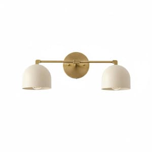 May include: A wall-mounted light fixture featuring a horizontal brass-toned metal bar attached to a circular backplate. Two dome-shaped, off-white shades are suspended from the ends of the bar, each housing a single light bulb facing downward.