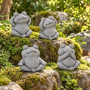Peut inclure: Quatre figurines de grenouilles en pierre grise à la texture mouchetée. Chaque grenouille est assise en tailleur. Une grenouille se couvre les yeux, une les oreilles, une la bouche, et la dernière a les mains posées sur ses genoux.