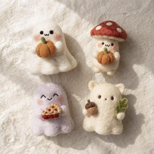 May include: Four needle-felted figures: a white ghost holding an orange pumpkin, a mushroom character with a red cap holding a pumpkin, a light purple ghost holding a slice of cherry pie, and a white bear-like figure holding an acorn and leaf.