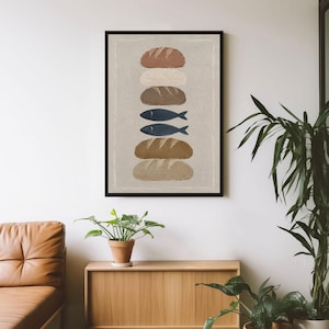 Op de afbeelding: Een ingelijste kunstdruk met een verticale stapel van zes items op een lichtbeige achtergrond. De stapel bevat vier broden in verschillende tinten bruin en beige, afgewisseld met twee donkerblauwe vissen in het midden.