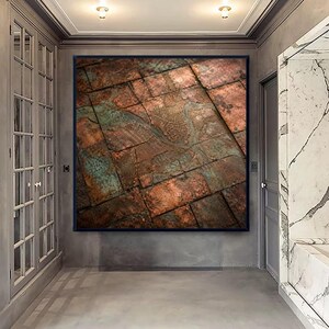 May include: A square wall art piece featuring a detailed aerial map of a city layout etched onto a grid of weathered copper plates. The surface displays a mix of metallic brown, bronze, and oxidized teal green tones with visible seams.