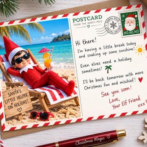 Op de afbeelding: Een rechthoekige ansichtkaart met een in het rood geklede elf met een zonnebril, liggend op een strandstoel met een tropisch drankje. De tekst luidt: POSTCARD FROM THE NORTH POLE, Hi there! I'm having a little break today and soaking up some sunshine! Even elves need a holiday sometimes! I'll be back tomorrow with more Christmas fun and mischief! See you soon! Love, Your Elf Friend. Een houten bordje zegt: SANTA'S LITTLE HELPER ON HOLIDAY!