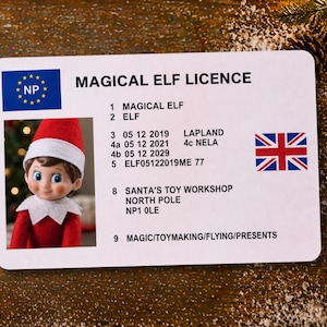 Pode incluir: Um cartão retangular branco intitulado MAGICAL ELF LICENCE com uma bandeira azul com estrelas amarelas, a Union Jack e uma fotografia de um elfo com um chapéu e colarinho vermelhos. O texto inclui detalhes como LAPLAND, SANTA'S TOY WORKSHOP e NORTH POLE.