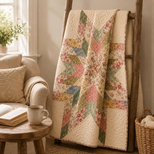 May include: A quilted blanket featuring a large central star pattern composed of various floral fabrics in shades of pink, green, yellow, and blue, set against a cream-colored background with a textured, stitched finish throughout the fabric.