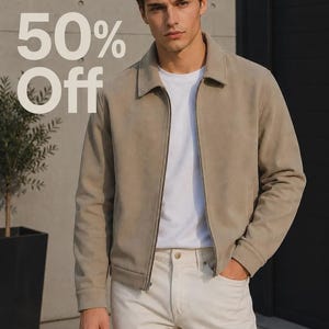 Puede incluir: Una chaqueta beige con cremallera y textura de ante con cuello clásico, sobre una camiseta blanca lisa y pantalones de color blanco roto. La imagen incluye el texto 50% Off superpuesto en el lado izquierdo, indicando un descuento promocional.