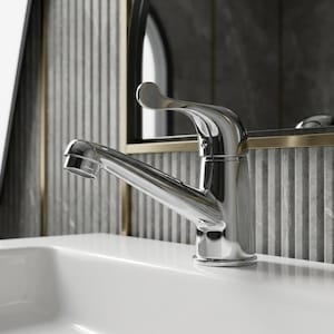 Pode incluir: Uma torneira de casa de banho em cromo polido com um manípulo de alavanca curvo único e uma base cilíndrica com detalhes estriados verticais, posicionada sobre um lavatório de cerâmica branca com acabamento refletor e design liso.