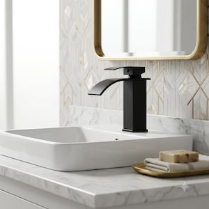 May include: A matte black bathroom faucet with a square base and a curved spout, positioned over a white rectangular ceramic sink basin. The faucet features a single lever handle on top for water control, set against a white marble countertop.
