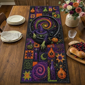 May include: A rectangular table runner featuring a vibrant Halloween-themed patchwork design. The central image shows a green-skinned witch in a purple hat emerging from a black cauldron, accompanied by a black cat and a small orange pumpkin.