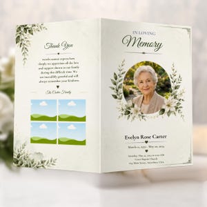 Könnte beinhalten: Ein gefaltetes Trauerprogramm mit cremefarbenem Hintergrund und grünen botanischen Akzenten. Die Vorderseite zeigt ein kreisförmiges Foto einer älteren Person, den Text In Loving Memory, Evelyn Rose Carter, Daten und Ort. Innen befindet sich ein Dankeschön.