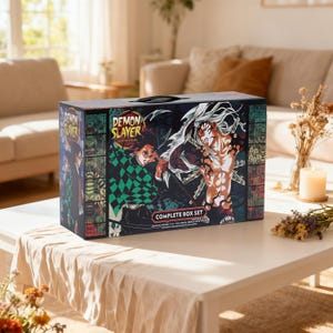 Könnte beinhalten: Ein rechteckiges Demon Slayer Komplett-Box-Set mit farbenfrohen Anime-Charakter-Illustrationen auf der Vorder- und Seitenwand. Die Box enthält den Text Demon Slayer, Kimetsu no Yaiba und Complete Box Set mit einem schwarzen Tragegriff.