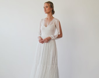 May include: A white lace wedding dress with long sleeves and a flowing skirt. The dress has a V-neckline and a fitted bodice.