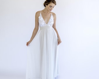 May include: A white sleeveless maxi dress with a plunging neckline and floral embroidery on the bodice.