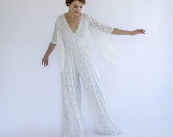 Mono de novia de encaje bohemio: escote en V profundo y mangas acampanadas.
