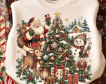 May include: A cream-colored crewneck sweatshirt featuring a festive holiday graphic. The illustration depicts Santa Claus, a reindeer, a snowman, and a nutcracker surrounding a decorated Christmas tree with gifts, a lantern, and a snowy cabin.