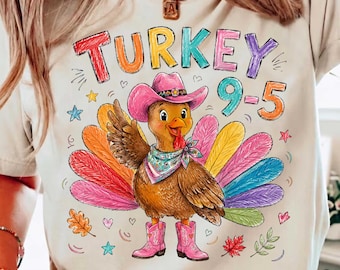 May include: A cream-colored t-shirt featuring a graphic of a brown turkey wearing a pink cowboy hat, a patterned bandana, and pink cowboy boots. The turkey has colorful feathers and is surrounded by small hearts, stars, and leaves. The text reads TURKEY 9-5.