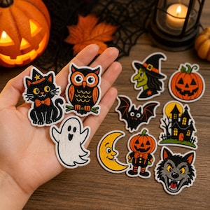 May include: A collection of embroidered Halloween-themed patches featuring a black cat, an owl, a white ghost, a witch, a jack-o'-lantern, a bat, a haunted house, a crescent moon, a pumpkin character, and a wolf face with sharp teeth.