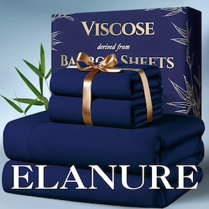 May include: A set of deep navy blue viscose sheets derived from bamboo, featuring a folded stack tied with a gold ribbon. The packaging box displays the text Viscose derived from BAMBOO SHEETS and the brand name ELANURE in large white letters.