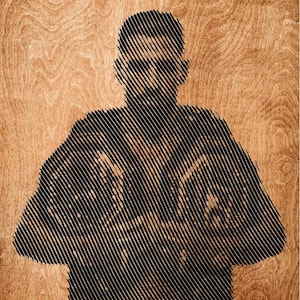 May include: A wooden wall art piece featuring a black line-art portrait of a fighter holding a championship belt. The image is composed of diagonal black lines against a natural light brown wood grain background with the text UFC FREEDOM at the top.