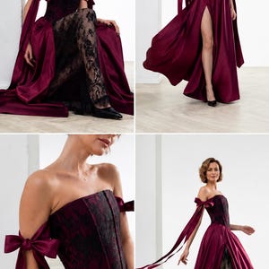 May include: A floor-length burgundy satin gown featuring a strapless corset bodice with black lace overlay, off-the-shoulder sleeves with long ribbon ties, and a high front slit revealing a black lace underskirt with a scalloped hemline.