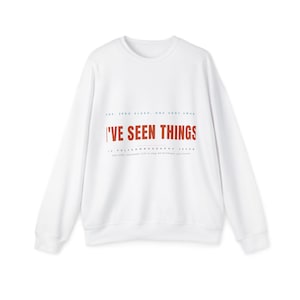 Könnte beinhalten: Ein weißes langärmeliges Sweatshirt mit Rundhalsausschnitt und dem Schriftzug I'VE SEEN THINGS in großen orangefarbenen Buchstaben auf der Brust. Kleinerer schwarzer Text darüber und darunter lautet ADS, ZERO SLEEP, ONE VERY AMAR und POLYSOMNOGRAPHY TECHN.