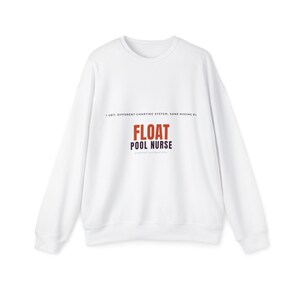 Könnte beinhalten: Ein weißes langärmeliges Sweatshirt mit Rundhalsausschnitt und dem auf die Brust gedruckten Text 1 UNIT. DIFFERENT CHARTING SYSTEM. SAME MISSING PEN. FLOAT POOL NURSE. Das Wort FLOAT ist orange, der restliche Text ist schwarz.