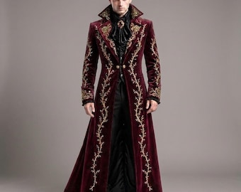 Può includere: Un lungo cappotto in velluto bordeaux scuro con intricati ricami dorati lungo i risvolti, i polsini e i pannelli frontali. Il cappotto presenta un colletto alto, due bottoni dorati in vita e una camicia nera con dettagli a volant.
