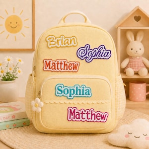 Puede incluir: Una mochila de color amarillo pálido con asa superior, bolsillo frontal con cremallera y bolsillos laterales con estampado de cuadros vichy en amarillo claro. Incluye cinco parches bordados con los nombres Brian, Sophia, Matthew, Sophia y Matthew.