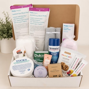 May include: A postpartum care kit in a cardboard box containing Frida Mom instant ice maxi pads, Tucks medicated cooling pads, Dermoplast pain, burn and itch spray, Dulcolax stool softener, KeaBabies nipple butter, Munchkin lactation cookies, and drink mix.