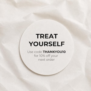 May include: A circular white sticker featuring the black text TREAT YOURSELF in a bold sans-serif font, followed by the smaller black text Use code THANKYOU10 for 10% off your next order, presented on a clean, neutral background.