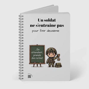 Pode incluir: Um caderno de espiral branco com um soldado de desenho animado segurando uma medalha de segundo lugar ao lado de um quadro-negro. O texto diz: Un soldat ne s'entraîne pas pour finir deuxième ...En attendant, prends des notes! Há um código QR na parte inferior.