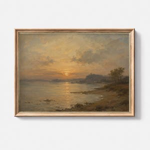 Puede incluir: Un cuadro de paisaje enmarcado que representa una puesta de sol sobre una masa de agua con una orilla, colinas lejanas y árboles. El cielo está lleno de suaves nubes doradas y anaranjadas que reflejan la luz sobre la superficie del agua en calma.