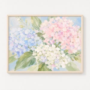 May include: A rectangular wall art print featuring an impressionistic painting of hydrangea flowers in shades of soft blue, pale pink, and creamy white, accented with muted green leaves against a light blue background, enclosed in a light wood frame.