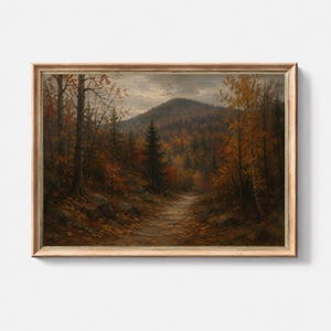 May include: A framed landscape painting depicting an autumn forest path leading toward a distant mountain. The scene features trees with orange and brown foliage, rocky terrain, and a cloudy sky, all enclosed within a light-toned wooden frame.