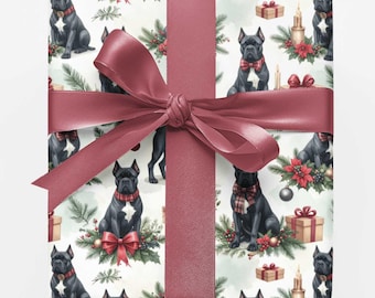 May include: A square gift box wrapped in white paper featuring a repeating pattern of black dogs, red bows, green pine branches, and brown gift boxes. A wide, dark red satin ribbon is tied in a large bow around the center of the package.