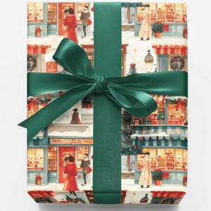 May include: A rectangular gift box wrapped in paper featuring a repeating illustration of a snowy street with storefronts, pedestrians in winter coats, and holiday decorations, tied with a wide, dark green satin ribbon in a centered bow.