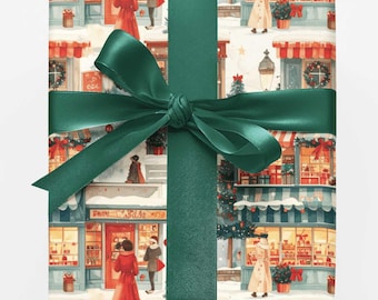 May include: A rectangular gift box wrapped in paper featuring a repeating illustration of a snowy street with storefronts, pedestrians in winter coats, and holiday decorations, tied with a wide, dark green satin ribbon in a centered bow.