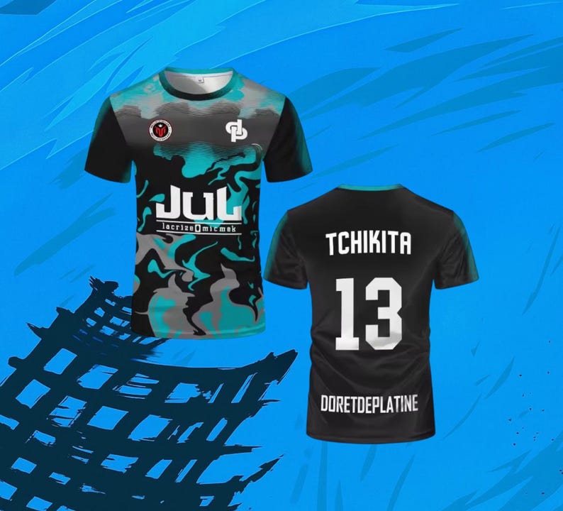 May include: A short-sleeve t-shirt featuring a black, teal, and gray marbled pattern on the front with the text JUL and lacrizeomicmak. The back is solid black with the white text TCHIKITA, the number 13, and the text DORETDEPLATINE at the bottom.
