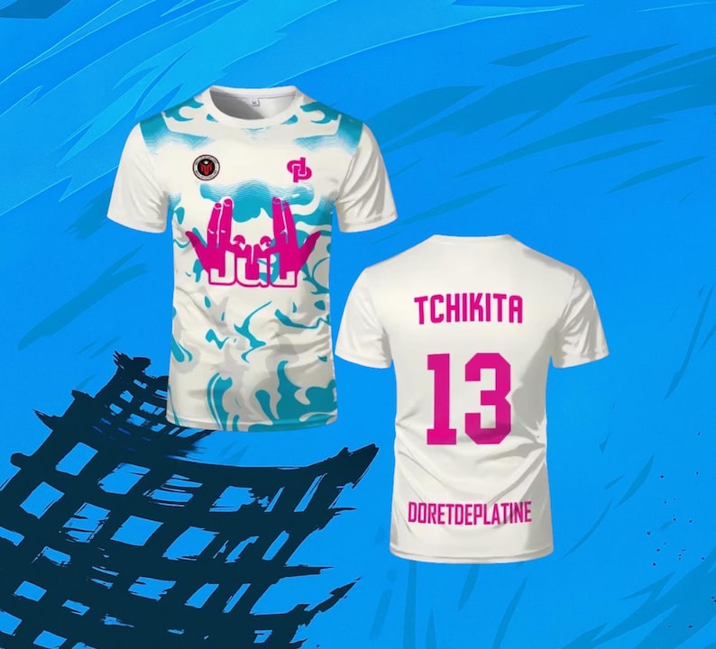 May include: A white short-sleeve t-shirt featuring a blue marbled pattern, a pink graphic of hands forming a sign above the text JUL, and a small logo on the chest. The back displays the text TCHIKITA, the number 13, and DORETDEPLATINE in pink.