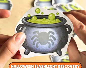 May include: A die-cut sticker featuring a dark gray cauldron with a light gray spider silhouette on the front. The cauldron is filled with a bright lime green bubbling liquid. The text HALLOWEEN FLASHLIGHT DISCOVERY is printed in white on an orange bar.