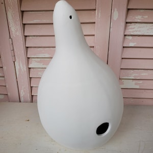 May include: White ceramic gourd-shaped birdhouse with a round opening on the side.