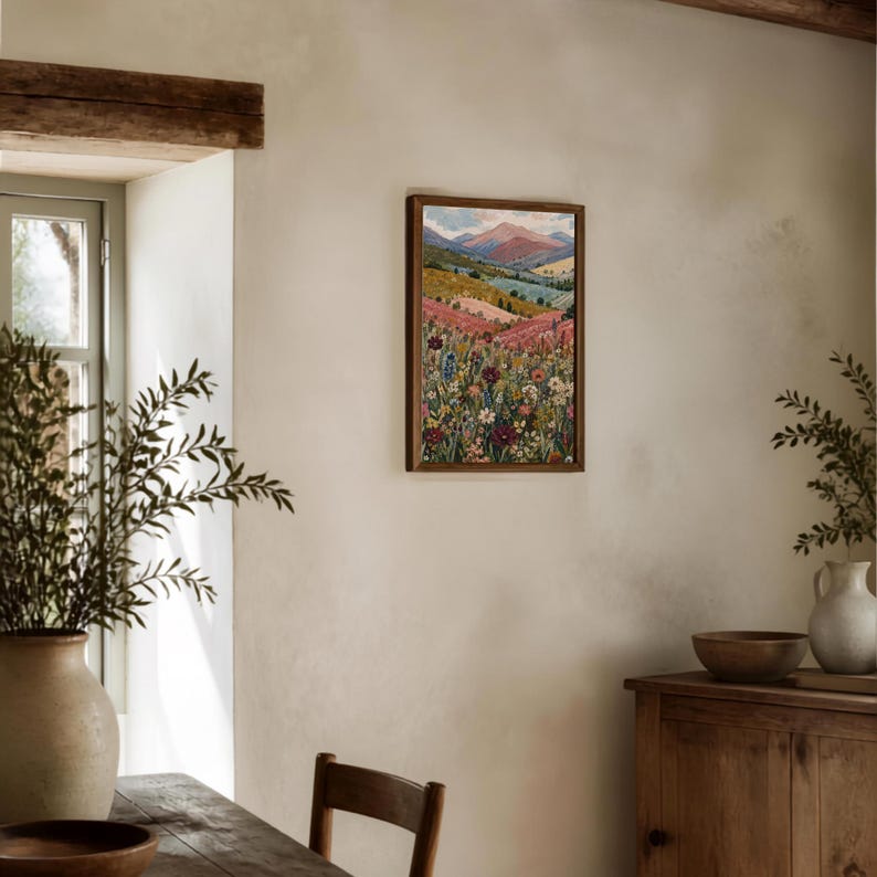 May include: A rectangular framed wall art print featuring a vibrant landscape painting. The artwork displays a foreground filled with colorful wildflowers in shades of pink, yellow, and blue, leading to rolling hills and distant mountains under a soft sky.