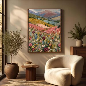 May include: A rectangular framed wall art print featuring a landscape painting of a vibrant wildflower meadow in the foreground with rolling hills and distant mountains in the background, rendered in shades of pink, yellow, green, and blue.