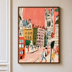 May include: A framed art print featuring a stylized urban street scene with a red double-decker bus, tall buildings in shades of yellow, green, and pink, and a prominent gothic-style tower against a coral sky, with figures walking on the street.