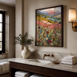 May include: A framed wall art print featuring a vibrant landscape painting of a wildflower meadow in the foreground with rolling hills and distant mountains in the background, rendered in shades of pink, yellow, green, and deep red.