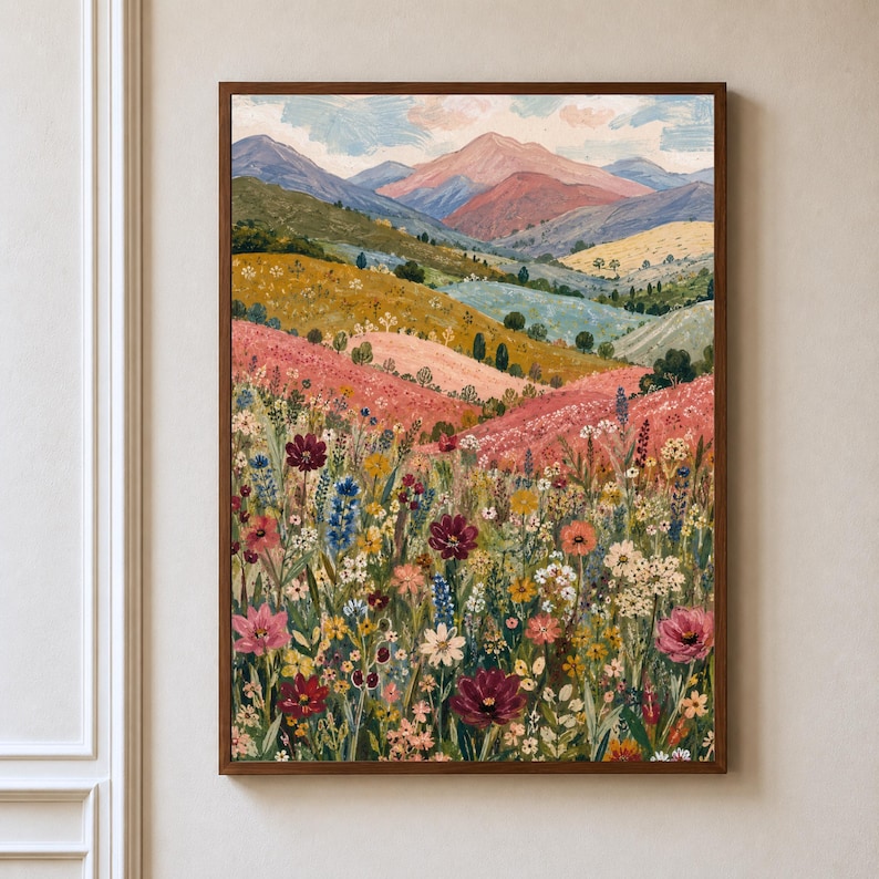 May include: A framed landscape painting featuring a vibrant wildflower meadow in the foreground with various colorful blooms in shades of red, pink, yellow, and blue, leading to rolling hills and distant mountains under a soft, cloudy sky.