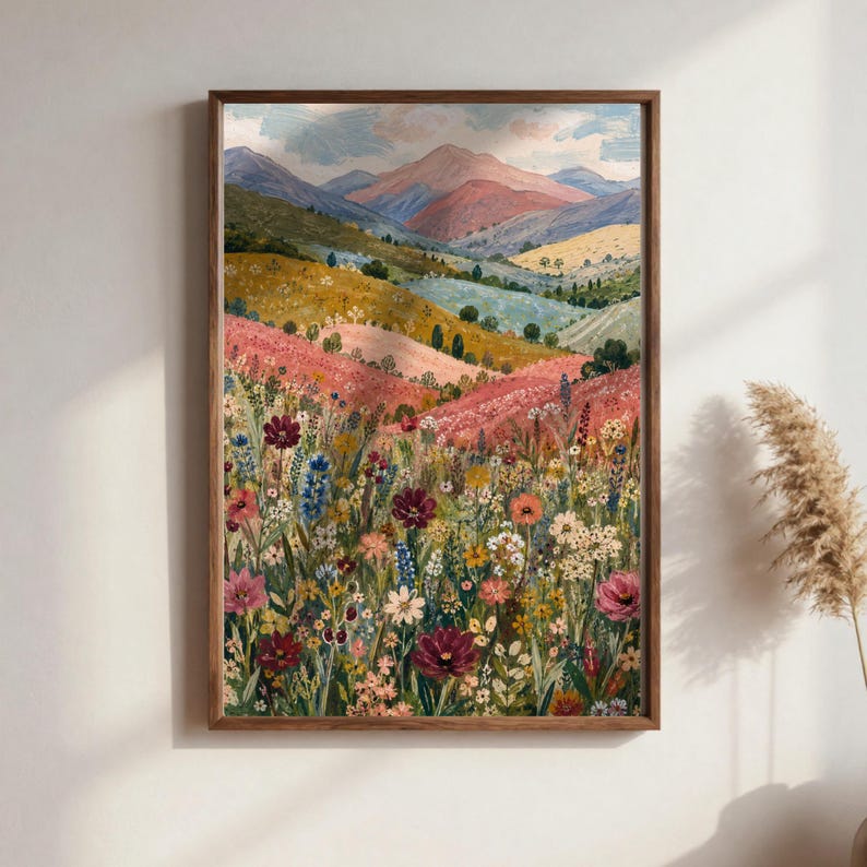 May include: A rectangular wall art print in a wooden frame featuring a landscape painting of a vibrant wildflower meadow in the foreground with rolling hills and distant mountains under a soft sky in shades of pink, blue, and yellow.
