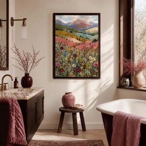 May include: A rectangular framed wall art print featuring a landscape painting of rolling hills, distant mountains, and a vibrant foreground filled with a dense variety of colorful wildflowers in shades of pink, red, yellow, blue, and white.